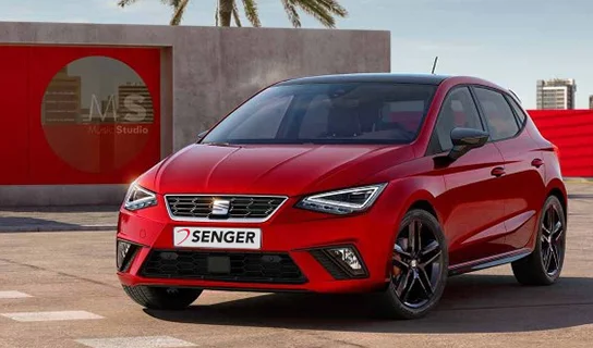 Ein roter SEAT Ibiza steht auf einem asphaltierten Platz vor einer rot-grauen Betonwand.