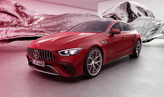 Ein roter Mercedes AMG steht auf einem neutralen Untergrund mit wehendem Stoff im Hintergrund.