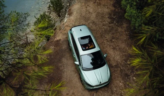 Grauer Skoda Enyaq parkend auf einem Waldparkplatz aus der Vogelperspektive fotografiert