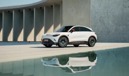 Ein weißer smart #3 steht zwischen einer Wasserfläche und einem Betonbogen.